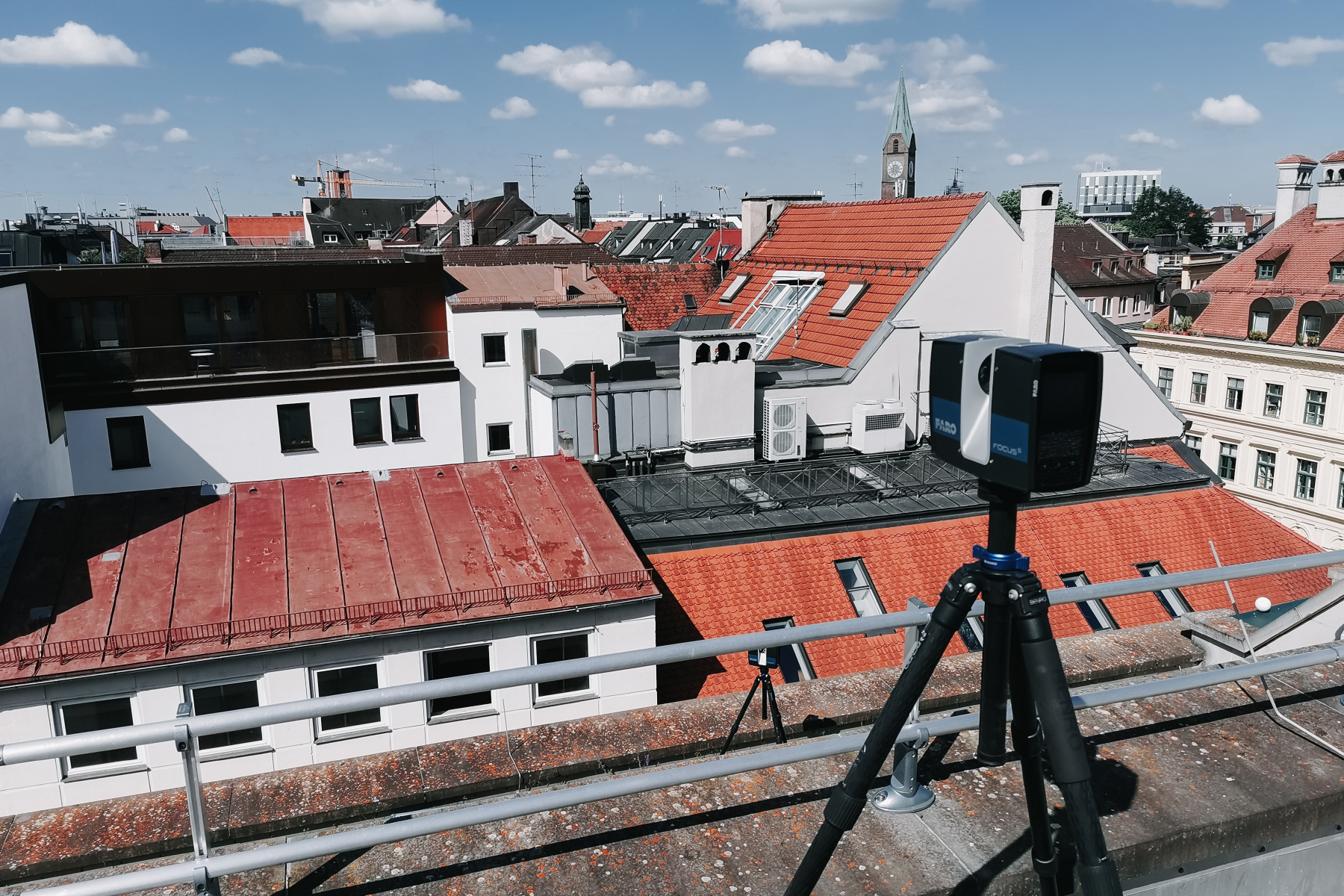 Skyline einer deutschen Stadt. Auf einem Dach ist der 3D-Laserscanner im Einsatz.
